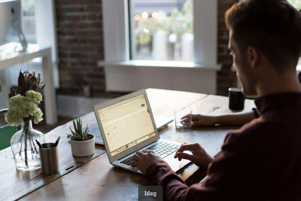 man operating laptop on top of table